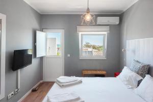 拉戈斯Lagos Uptown Bed & Breakfast的一间卧室设有一张床、一台电视和一个窗口。