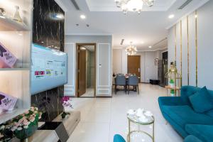 胡志明市VINHOMES LANDMARK CONDOTEL SUITE的客厅配有蓝色的沙发和电视