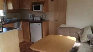 斯凯格内斯3-Bed 8 berth static caravan in ingoldmells的一个带桌子和台面的小厨房