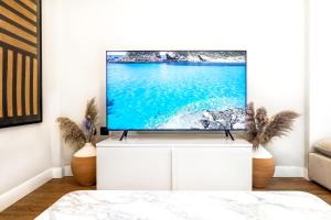 莫拉卡里瓦Iconic PRIVE beachfront villa Mola Kaliva的客厅配有白色橱柜上的平面电视