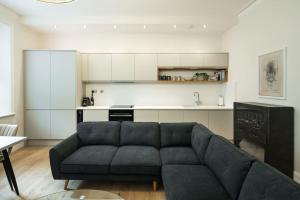 伦敦Stylish 2 Bed Flat in Holland Park/ Notting Hill的带沙发的客厅和厨房