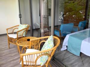 康隆尼角Residence Le Point Choisy的门廊配有藤椅、桌子和桌椅