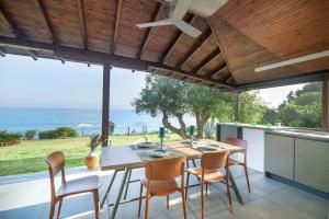 莫拉卡里瓦Iconic PRIVE beachfront villa Mola Kaliva的一间带桌椅的海景用餐室