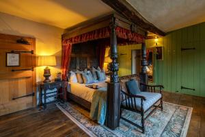 诺顿圣菲The George Inn & Plaine的一间卧室配有一张带壁炉和椅子的床。