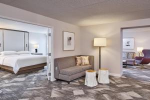 波特兰波特兰机场喜来登酒店 的一间卧室配有一张床、一张沙发和一把椅子
