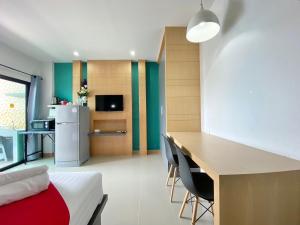 Ban KlangPhoomjai Service Apartment的客房设有一张床、一张书桌和一间厨房