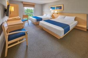 阿瓜斯卡连特斯阿瓜斯卡连特斯苏尔城市快捷酒店的一间酒店客房,设有两张床和电视