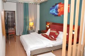 波多诺伏Freedom Palace Hôtel的一间卧室配有带白色床单和红色枕头的床。