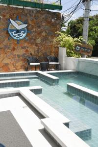 莫罗圣保罗Pousada Bahia Inn的一个带椅子的游泳池,墙上有标志