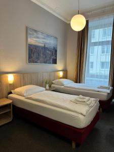 汉堡Hotel Kieler Hof am Hauptbahnhof - Hamburg Central Station的配有大窗户的酒店客房内的两张床