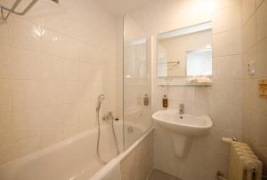 库特纳霍拉LH Hotel Mědínek Old Town的白色的浴室设有水槽和淋浴。