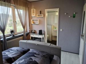 ÜdersdorfGasthaus Paula的一间卧室设有一张床、一个窗口和一面镜子