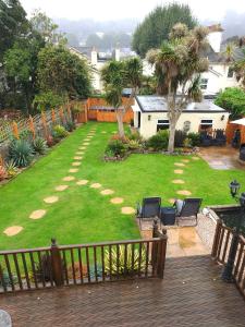 托基阿佩托里度假公寓的后院设有草坪,种植了椅子和树木