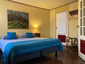 赫鲁德Hotel Groede的一间卧室配有一张带蓝色毯子的床