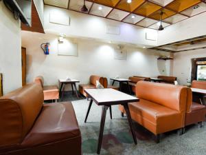 坎普尔Hotel Atithi Galaxy Kanpur Near Railway Station Kanpur - Wonderfull Stay with Family的一间设有棕色皮革椅子和桌子的等候室