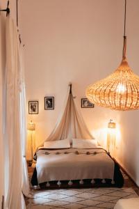 马拉喀什NOSADE Venue的一间卧室配有一张床和一个吊灯