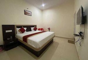 瓦拉纳西Hotel Nath Palace Chunar Road Varanasi - Luxury Room - Excellent Service Recommended的一间卧室配有一张床和一台电视