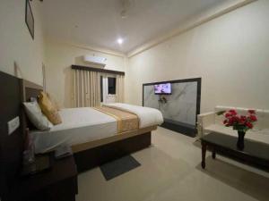 瓦拉纳西Hotel Nath Palace Chunar Road Varanasi - Luxury Room - Excellent Service Recommended的一间卧室配有一张床和一台电视。