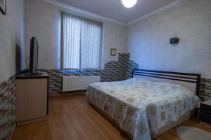 塞凡Sevan Private Guest House的一间卧室配有一张床和一台平面电视