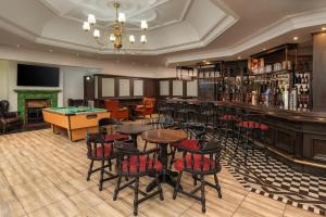 约翰内斯堡Holiday Inn - Johannesburg Sunnyside Park, an IHG Hotel的酒吧配有桌椅和台球桌