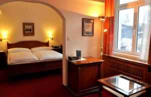 圣莫里茨索尔达纳拉酒店的一间卧室配有一张床、一张书桌和一个窗户。