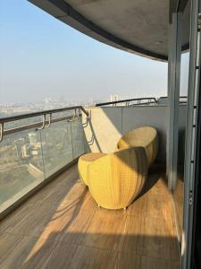 新德里Urban Serenity的阳台顶部的黄色椅子