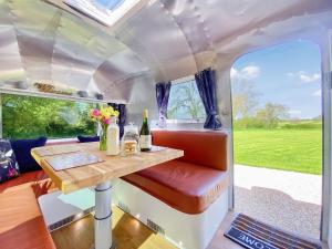 HawthornLanes End Farm Airstream的享有大篷车的内部景致,设有桌子和窗户。