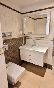 圣莫里茨索尔达纳拉酒店的浴室配有白色水槽和卫生间。