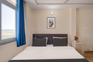 斋浦尔OYO Samrat P Guest House的一间卧室配有一张带蓝色窗帘的大床