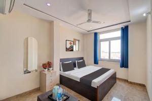 斋浦尔OYO Samrat P Guest House的一间卧室设有一张大床和一个窗户。
