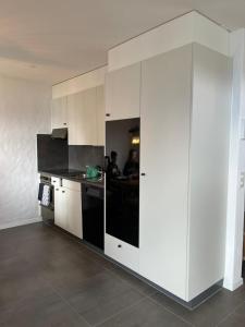 塞利斯贝格LakeHill72的厨房配有白色橱柜和黑色用具