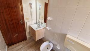 兰佩杜萨里佩拉吉耶酒店的一间带水槽、卫生间和镜子的浴室
