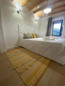阿尔德亚达斯Casinha Pôr do Sol的卧室配有一张大白色的床和地毯