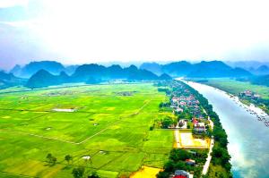 峰牙Happy field homestay的享有河流的空中景色,以山脉为背景