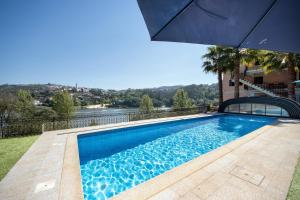 CrestumaPorto Douro - appartement 1的一座房子旁带遮阳伞的游泳池