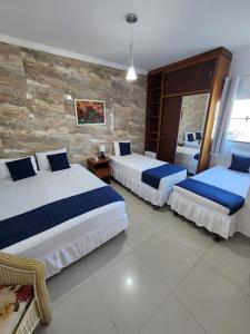 萨尔瓦多Hotel Park Stella Mares的一间卧室设有两张床和砖墙