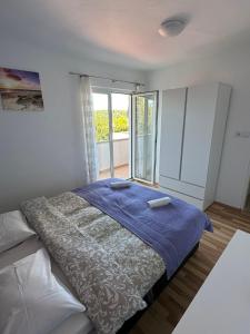 坎普尔Family Deluxe Apartment Mirjana的一间卧室设有一张床和一个大窗户