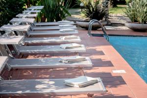 加尔多内-里维耶拉贝尔维尤酒店 的游泳池旁的一排躺椅