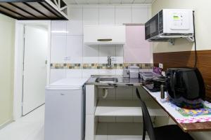 圣保罗38 LOFT DUPLO · LOFT perto da São PauloExpo /Aeroporto Congonhas的白色的厨房配有水槽和微波炉