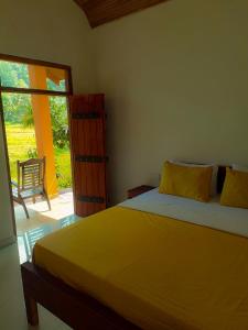 马特勒Sinharaja Cabana的一间卧室设有黄色的床和滑动玻璃门