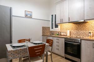 雅典Apartment @Katehaki Metro的厨房配有桌椅和台面