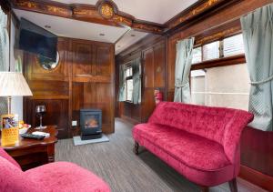 雷文格拉斯Irt Pullman Carriage的客厅设有红色的沙发和壁炉