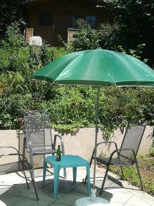 伯海姆基兴附近卡斯滕3072 Apartment MITTERFELD - Top A的绿色雨伞和桌椅