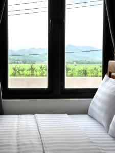 峰牙Happy field homestay的一间卧室设有一张床和两个美景窗户。