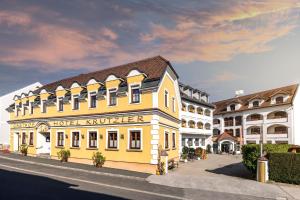 HeiligenbrunnGenussgasthof & Hotel beim Krutzler的两栋建筑旁街道上的黄色建筑