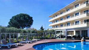 埃斯塔蒂特Apartamentos La Masia的大楼前设有游泳池的酒店