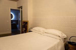 拉奎拉Ginevra Boutique Rooms - Palazzo Leosini - Residenze D'Epoca的一张带白色床单和枕头的床