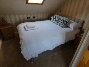 塔伯特The Moorings的卧室配有白色的床和枕头。