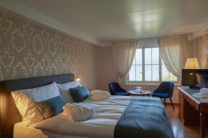 穆尔滕希夫阿姆西酒店的一间卧室配有一张床、一张书桌和一台电视