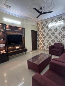 瓦拉纳西Kashi Anadam HomeStay的带沙发和大电视的客厅
